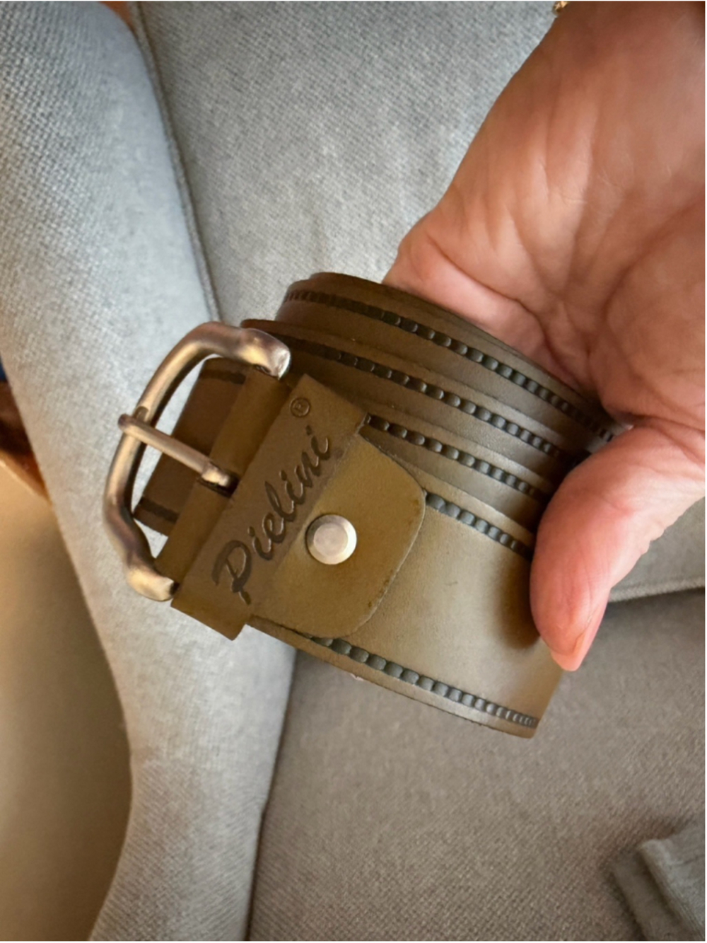 Pielini belt features a distinct studded border design and a metallic buckle.